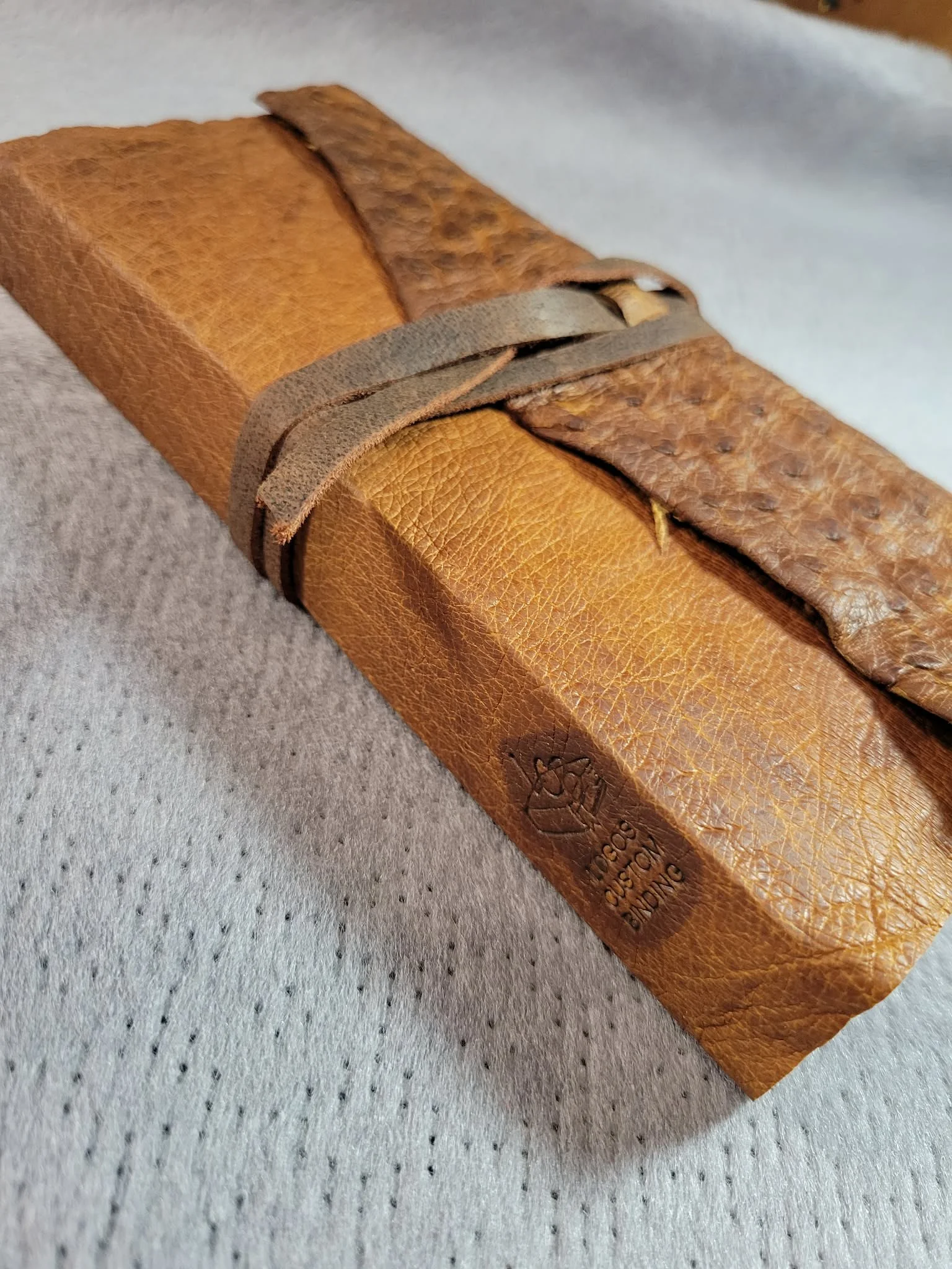 Raw-cut brown oily ostrich with flap and strap.